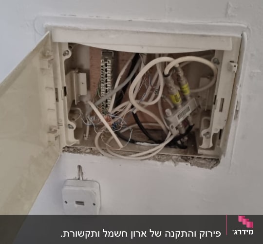 ארון חשמל פתוח עם חוטים חשמליים חשופים